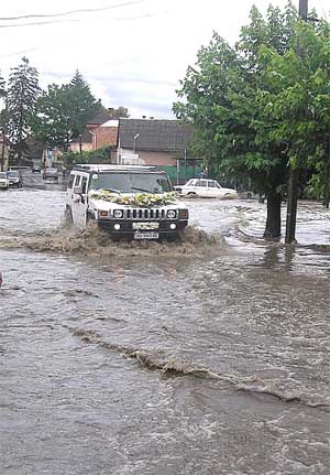 Весільний автомобіль проїжджає затоплене перехрестя вулиць Тельмана, Української та Дворжика в Ужгороді