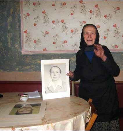 Анна Штулер из села Ворочево держит свой портрет, который висел на доске почета