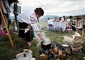 Женщина готовит на костре блюдо из картофеля во время фестиваля "Гуцульська ріпа"