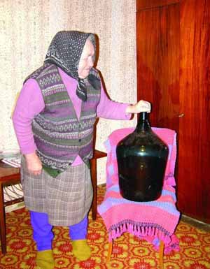 Мария Варга из села Арданово на Закарпатье показывает 25-литровую бутыль водки, которую выгнала 25 лет назад