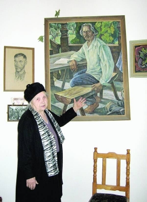 Марія Чендей біля картини, на якій зображений її чоловік