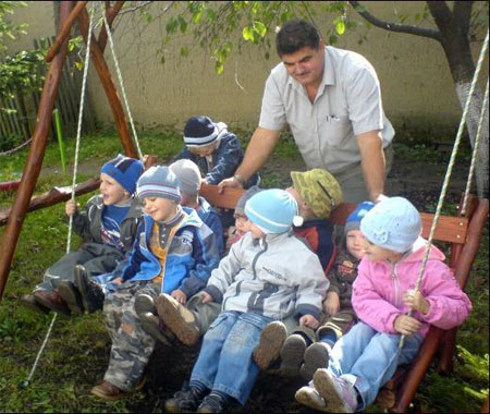 Павел Чучка играет с детьми в местном детском садике, который он отремонтировал за собственные средства